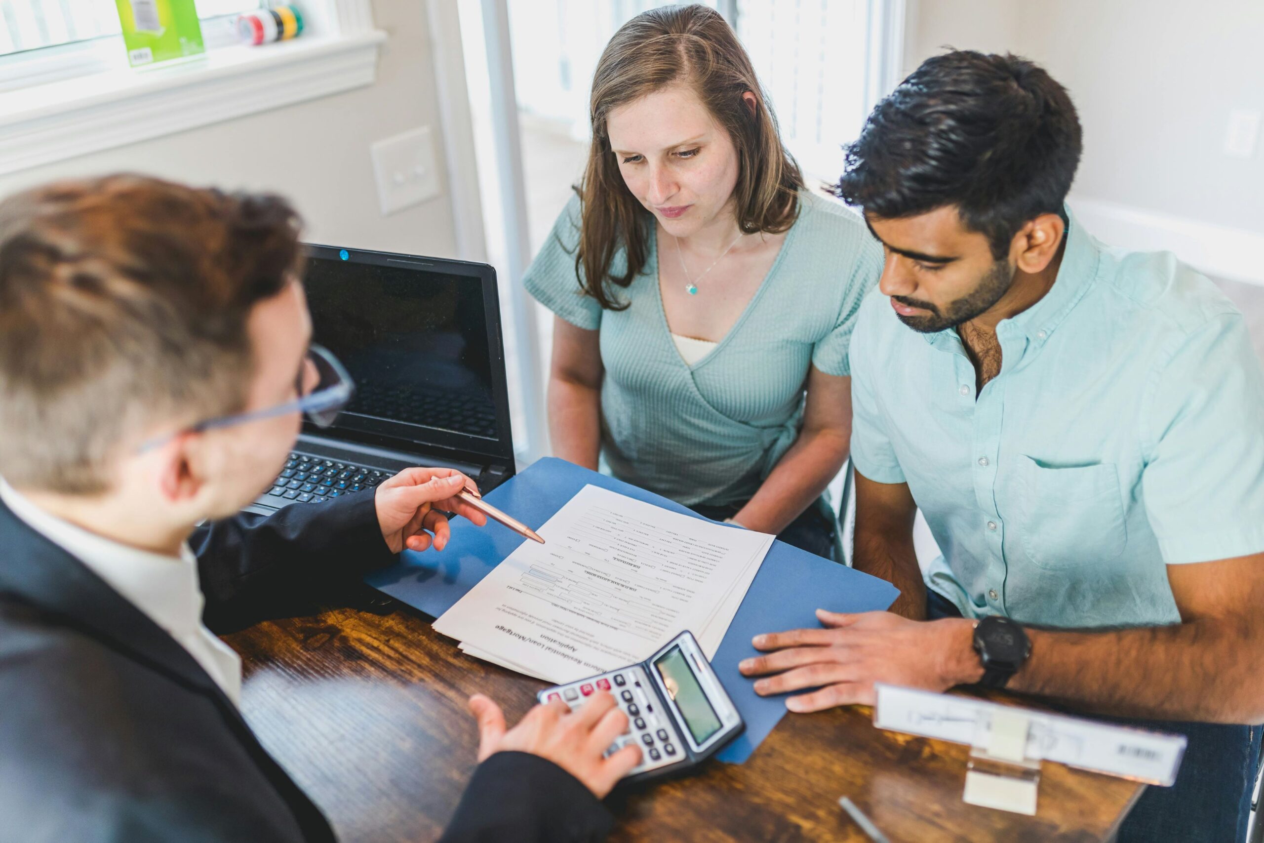 A couple is engaged in a discussion with a male broker.