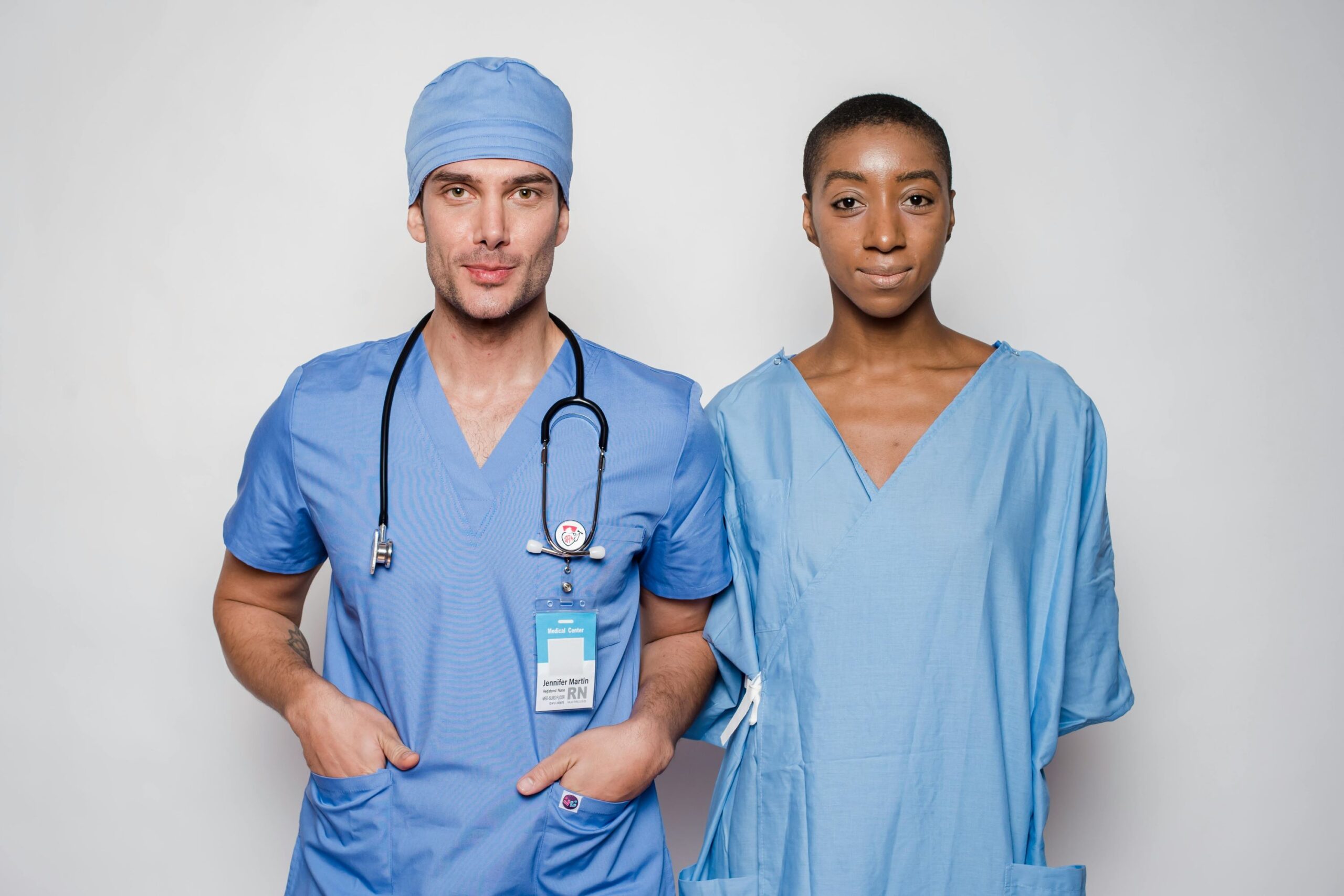 Two hospital nurses are standing side by side.